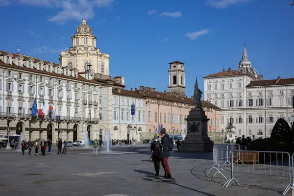Torino, İtalya - 08 Kasım 2021: Palazzo Madama 'nın yer aldığı Piazza Castello, Kraliyet Sarayı, bir anıt, çeşmeler ve açık mavi gökyüzü altında ince bulutlu sayısız yayalar
