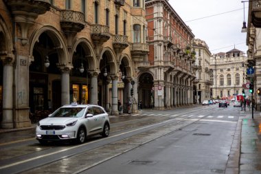 Torino, İtalya - 10 Kasım 2021: Via Pietro Micca boyunca sokak manzarası solda Palazzo Bellia ve caddeden geçen yayalar.