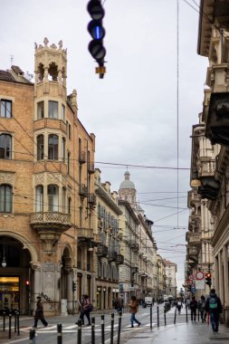 Torino, İtalya - 10 Kasım 2021: Via Pietro Micca boyunca sokak manzarası solda Palazzo Bellia ve caddeden geçen yayalar.