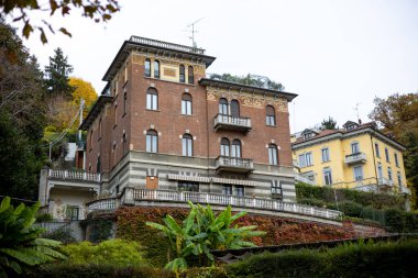 Torino, İtalya - 09 Kasım 2021: Sonbahar yapraklı bir yamaçtaki villalar