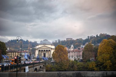 Torino, İtalya - 08 Kasım 2021: Chiesa Parrocchiale della Gran Madre di Dio ve Turin silueti, Po Nehri üzerindeki Ponte Vittorio Emanuele I köprüsünden sonbahar yeşillikleriyle
