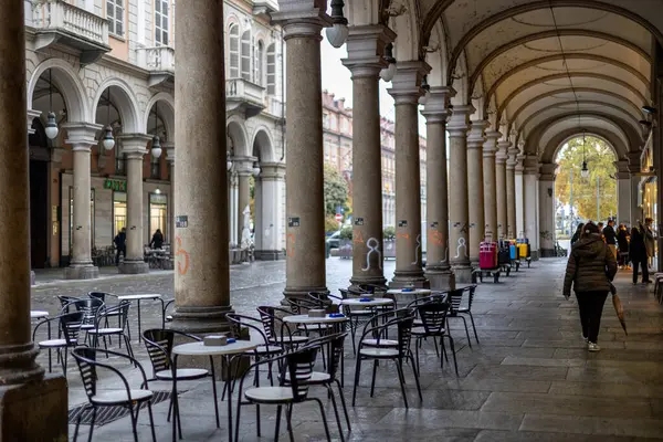 Torino, İtalya - 10 Kasım 2021: Portikolar Via Giuseppe Garibaldi boyunca insanların önünden geçtiği açık kafe.
