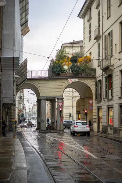 Torino, İtalya - 08 Kasım 2021: Islak bir şehir caddesinde kemerli yürüyüş yolları olan arabalar