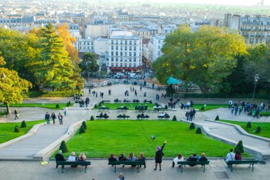 Paris, Fransa - 9 Kasım 2011: Sacre-Ceour yakınlarındaki Montmartre 'de, mor bereli tuhaf bir kadın Edith Piaf' i mizahi bir şekilde taklit ediyor. Hareketleri, yoldan geçenlerin dikkatini çekiyor..