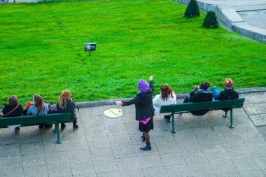 Paris, Fransa - 9 Kasım 2011: Sacre-Ceour yakınlarındaki Montmartre 'de, mor bereli tuhaf bir kadın Edith Piaf' i mizahi bir şekilde taklit ediyor. Hareketleri, yoldan geçenlerin dikkatini çekiyor..