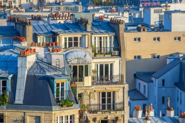Paris, Fransa - 9 Kasım 2011: Montmartre 'nin çatılarının manzarası büyüleyici Paris mimarisini gözler önüne seriyor. Sahnede mavi-gri fayanslar, bacalar, tavan pencereleri ve yatakhane pencereleri vurgulanıyor.