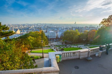 Paris, Fransa - 9 Kasım 2011: Parkın Montmartre tepesinden ve Paris panoramasından görüntü. İnsanlar sıcak bir sonbahar akşamı parkta yürüyorlar..