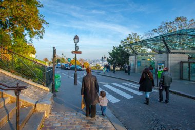 Paris, Fransa - 9 Kasım 2011: Montmartre Sacre-Ceour Bazilikası yakınlarında. Çamurlu sokaklar ağaçlarla çevrili taş merdivenlere çıkar. Ziyaretçiler, doğa ve şehir cazibesinin karışımından zevk alarak bölgede yürüyorlar..