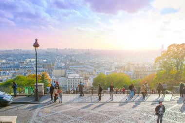 Paris, Fransa - 9 Kasım 2011: İnsanlar günbatımında yüksek bir perspektiften Paris 'in panoramik manzarasının keyfini çıkarıyorlar, ön planda bir sokak lambası ve sıcak ışıkla yıkanan şehir.