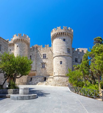Güneşli, alçak açılı bir atış, Rodos Şövalyeleri 'nin Büyük Üstadı' nın sarayının taş cephelerini ve yuvarlak kulelerini açık mavi gökyüzünün altında yakalar..