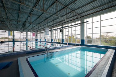 Rodos 'taki Kolona Limanı' nın berrak mavi sularına yanaşan bir yolcu gemisinin arka planında Fransız Kulesi ve birkaç özel yatı da demirlemiş. Bulanık yüzler. İnsanlar sahilde dinleniyor.