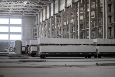 Havalandırılmış beton bloklar, AAC blokları (Otoklavize havalandırmalı beton), Fly ash veya Grey Cement Fly Ash Bricks endüstriyel üretimi. Bir otoklavda işlendikten sonra kesme blokları olan arabalar tedavi edilir.