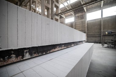 Havalandırılmış beton bloklar, AAC blokları (Otoklavize havalandırmalı beton), Fly ash veya Grey Cement Fly Ash Bricks endüstriyel üretimi. Bir otoklavda işlendikten sonra kesme blokları olan arabalar tedavi edilir.