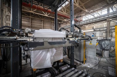 Havalandırmalı beton bloklar, AAC blokları (Otoklavize havalandırmalı beton), Gri Çimento Uçan Kül Tuğlaları endüstriyel üretim. Tamamlanmış ürünler ahşap paletlere yığılır ve plastik ambalaja konur..