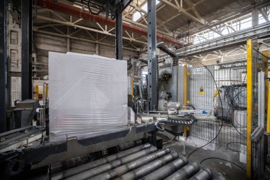 Havalandırmalı beton bloklar, AAC blokları (Otoklavize havalandırmalı beton), Gri Çimento Uçan Kül Tuğlaları endüstriyel üretim. Tamamlanmış ürünler ahşap paletlere yığılır ve plastik ambalaja konur..