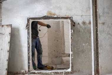 Havalandırılmış beton blokların endüstriyel üretimi, AAC blokları (Otoklavize edilmiş beton). İşçi, birleşik karışımın karıştırıcısının onarımına hazırlık çalışmalarını sürdürüyor..