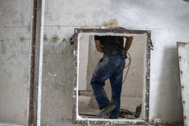 Havalandırılmış beton blokların endüstriyel üretimi, AAC blokları (Otoklavize edilmiş beton). İşçi, birleşik karışımın karıştırıcısının onarımına hazırlık çalışmalarını sürdürüyor..