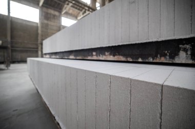 Havalandırılmış beton bloklar, AAC blokları (Otoklavize havalandırmalı beton), Fly ash veya Grey Cement Fly Ash Bricks endüstriyel üretimi. Bir otoklavda işlendikten sonra kesme blokları olan arabalar tedavi edilir.