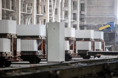 Havalandırılmış beton bloklar, AAC blokları (Otoklavize havalandırmalı beton), Fly ash veya Grey Cement Fly Ash Bricks endüstriyel üretimi. Bir otoklavda işlendikten sonra kesme blokları olan arabalar tedavi edilir.