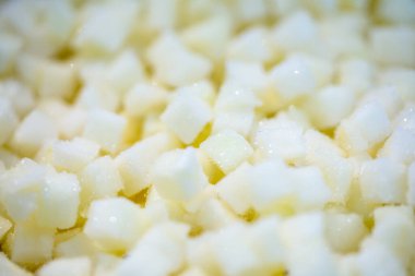 İnce buz kaplamalı, şokla dondurulmuş kavun küplerine yakın çekim. Tazelik ve dokuyu vurguluyor. Perakende satışta uzun raf ömrü sağlamak ve bozulabilir hasatları korumak için perakende paketleme için hazırlandı