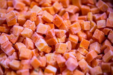 İnce buz kaplamalı dondurulmuş kırmızı dolma biber küplerinin yakın çekimi. Perakende satışlar ve bozulabilir hasatların korunması için uzun raf ömrü sağlamak üzere ambalaj işlemine hazırlandı.