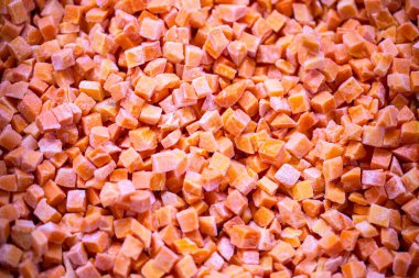 İnce buz kaplamalı dondurulmuş kırmızı dolma biber küplerinin yakın çekimi. Perakende satışlar ve bozulabilir hasatların korunması için uzun raf ömrü sağlamak üzere ambalaj işlemine hazırlandı.