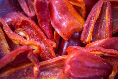 Dondurulmuş kırmızı biber parçalarının yakın planında ince bir buz tabakası ve korunmuş tazelik. Perakende satışlar ve bozulabilir hasatların korunması için uzun raf ömrü sağlamak üzere ambalaj işlemine hazırlandı.