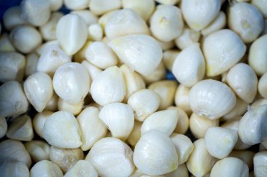 İnce buz kaplamalı, dondurulmuş sarımsak soğanlarının yakın çekimi. Süpermarketlerde raf ömrünün uzatılması ve bozulabilir hasat kalitesinin korunması için perakende paketlemeye hazırlar..