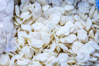 İnce buz kaplamalı, dondurulmuş sarımsaklı sarımsak dilimine yakın çekim. Süpermarketlerde raf ömrünün uzatılması ve bozulabilir hasat kalitesinin korunması için perakende paketlemeye hazırlar..