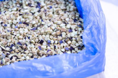 İnce buz kaplamalı dondurulmuş patlıcan yakın plan. Süpermarketlerde raf ömrünün uzatılması ve bozulabilir hasat kalitesinin korunması için perakende paketlemeye hazırlar..