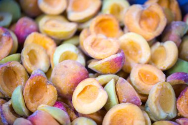 İnce buz kaplamalı, şok olmuş, olgun, pembe kayısı yarımları. Süpermarketlerde raf ömrünün uzatılması ve bozulabilir hasat kalitesinin korunması için perakende paketlemeye hazırlar..