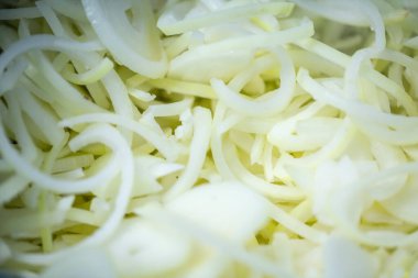 Donmuş soğan halkaları ve ince buz kaplamalı yarım halkalar yakın çekim. Süpermarketlerde raf ömrünün uzatılması ve bozulabilir hasat kalitesinin korunması için perakende paketlemeye hazırlar..