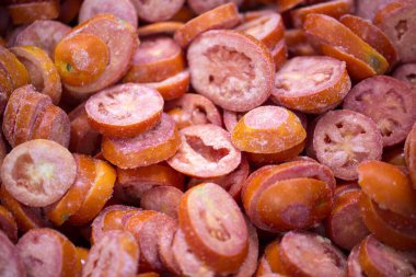 İnce buz kaplamalı, dondurulmuş kırmızı domateslerin yakın çekimi. Süpermarketlerde raf ömrünün uzatılması ve bozulabilir hasat kalitesinin korunması için perakende paketlemeye hazırlar..