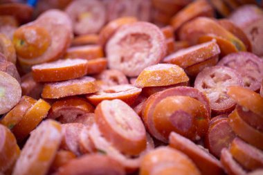 İnce buz kaplamalı, dondurulmuş kırmızı domateslerin yakın çekimi. Süpermarketlerde raf ömrünün uzatılması ve bozulabilir hasat kalitesinin korunması için perakende paketlemeye hazırlar..