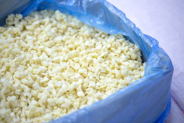 İnce buz kaplamalı, dondurulmuş sarımsaklı sarımsak parçalarının yakın çekimi. Süpermarketlerde raf ömrünün uzatılması ve bozulabilir hasat kalitesinin korunması için perakende paketlemeye hazırlar..