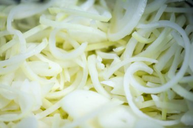 Donmuş soğan halkaları ve ince buz kaplamalı yarım halkalar yakın çekim. Süpermarketlerde raf ömrünün uzatılması ve bozulabilir hasat kalitesinin korunması için perakende paketlemeye hazırlar..