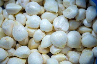 İnce buz kaplamalı, dondurulmuş sarımsak soğanlarının yakın çekimi. Süpermarketlerde raf ömrünün uzatılması ve bozulabilir hasat kalitesinin korunması için perakende paketlemeye hazırlar..