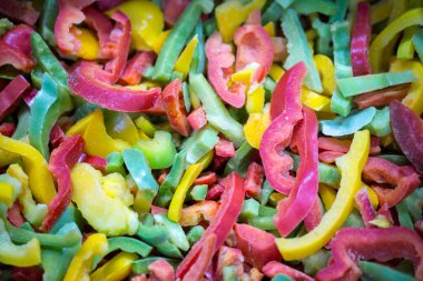 Kırmızı, sarı ve yeşil çeşitleri de içeren dondurulmuş tatlı biber karışımına yakın çekim. Süpermarketlerde perakende paketlemeye ve bozulabilir hasat kalitesini korumaya hazır..