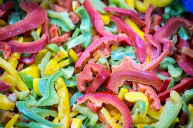 Kırmızı, sarı ve yeşil çeşitleri de içeren dondurulmuş tatlı biber karışımına yakın çekim. Süpermarketlerde perakende paketlemeye ve bozulabilir hasat kalitesini korumaya hazır..