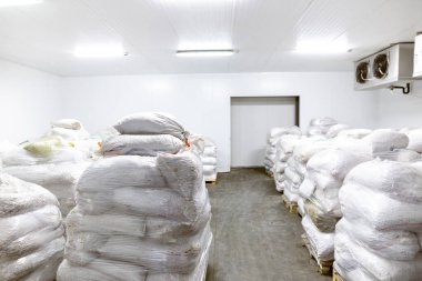 Dondurucu yöntemle dondurulmuş gıda ürünleri için soğuk hava deposu. Ürünler poşetlere doldurulur ve organize depolama ve dağıtım için ahşap paletlere yerleştirilir.