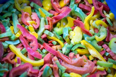 Kırmızı, sarı ve yeşil çeşitleri de içeren dondurulmuş tatlı biber karışımına yakın çekim. Süpermarketlerde perakende paketlemeye ve bozulabilir hasat kalitesini korumaya hazır..