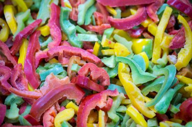 Kırmızı, sarı ve yeşil çeşitleri de içeren dondurulmuş tatlı biber karışımına yakın çekim. Süpermarketlerde perakende paketlemeye ve bozulabilir hasat kalitesini korumaya hazır..