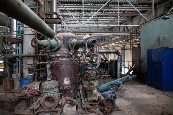 Parçalanmış endüstriyel vana bakım ve onarım aşamasında. Metal kaplama, cıvatalar, iç bileşenler ayrıntılı mekanik parçaları ve yapılandırılmış mühendisliği gösteren bir tezgah üzerinde düzenlenmiştir.