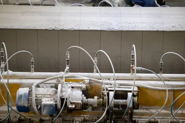 Havalandırılmış beton bloklar, AAC blokları (Otoklavize havalandırmalı beton), Fly ash veya Grey Cement Fly Ash Bricks endüstriyel üretimi. Makine, büyük iş parçalarını çelik tellerle keser..