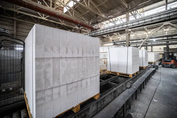 Havalandırılmış beton bloklar, AAC blokları (Otoklavize havalandırmalı beton), Fly ash veya Grey Cement Fly Ash Bricks endüstriyel üretimi. Tamamlanmış ürünler ahşap paletlerin üzerine istiflenmiştir.