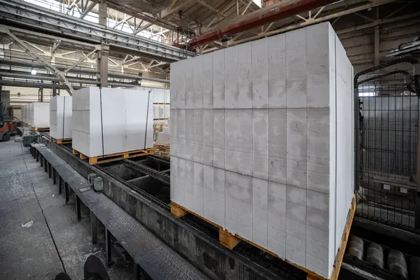 Havalandırılmış beton bloklar, AAC blokları (Otoklavize havalandırmalı beton), Fly ash veya Grey Cement Fly Ash Bricks endüstriyel üretimi. Tamamlanmış ürünler ahşap paletlerin üzerine istiflenmiştir.
