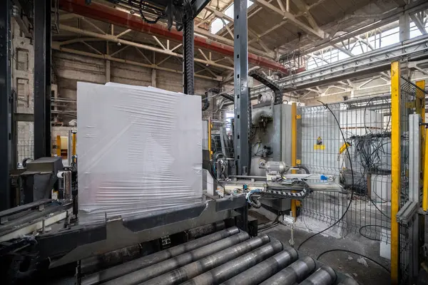 Havalandırmalı beton bloklar, AAC blokları (Otoklavize havalandırmalı beton), Gri Çimento Uçan Kül Tuğlaları endüstriyel üretim. Tamamlanmış ürünler ahşap paletlere yığılır ve plastik ambalaja konur..