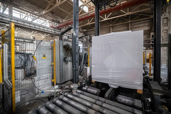 Havalandırmalı beton bloklar, AAC blokları (Otoklavize havalandırmalı beton), Gri Çimento Uçan Kül Tuğlaları endüstriyel üretim. Tamamlanmış ürünler ahşap paletlere yığılır ve plastik ambalaja konur..