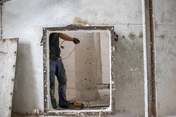 Havalandırılmış beton blokların endüstriyel üretimi, AAC blokları (Otoklavize edilmiş beton). İşçi, birleşik karışımın karıştırıcısının onarımına hazırlık çalışmalarını sürdürüyor..