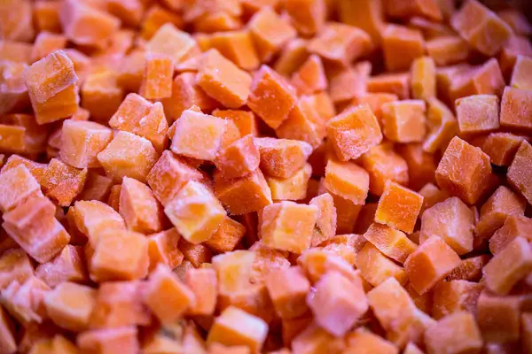 İnce buz kaplamalı dondurulmuş kırmızı dolma biber küplerinin yakın çekimi. Perakende satışlar ve bozulabilir hasatların korunması için uzun raf ömrü sağlamak üzere ambalaj işlemine hazırlandı.